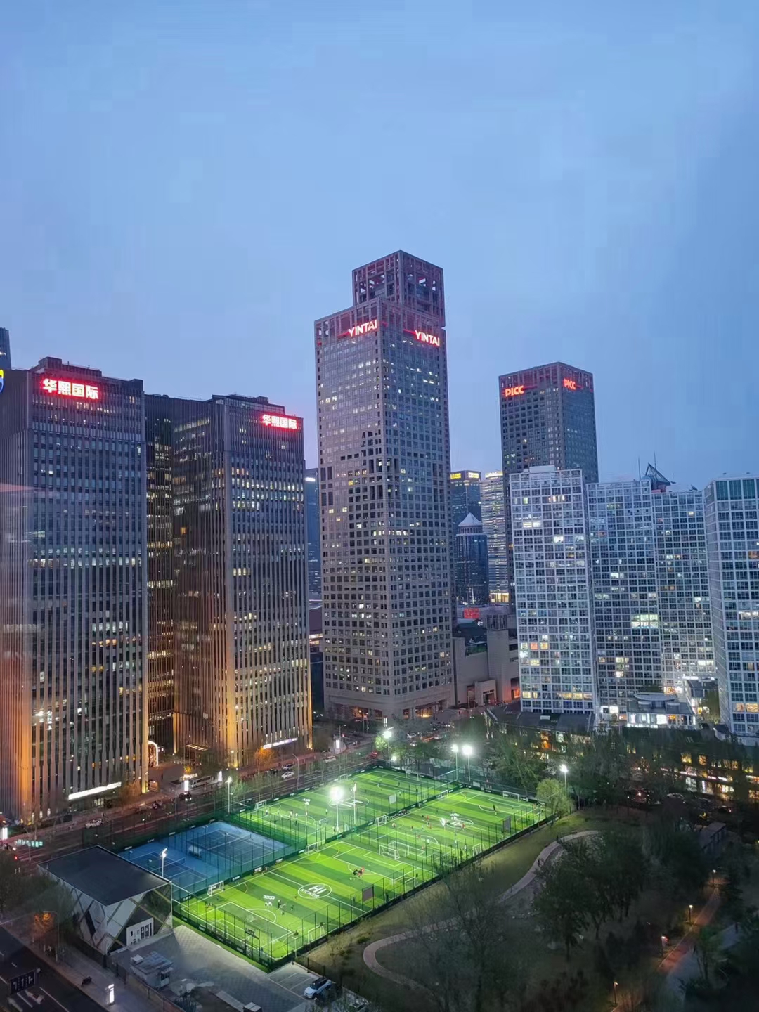 北京 CBD 文化体育广场的夜间足球场与周边建筑